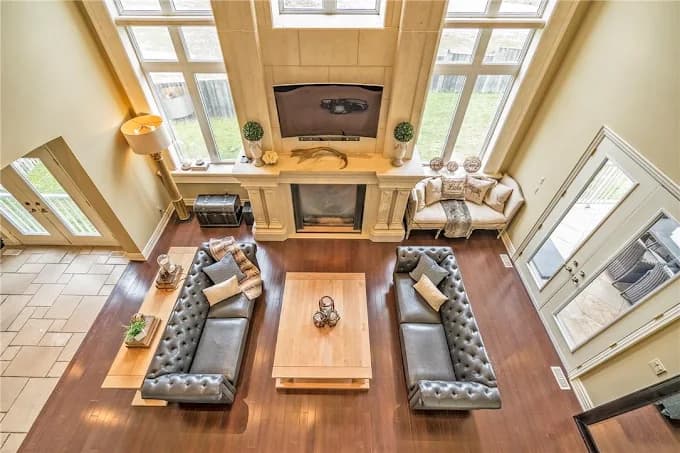 Open living room with stone fireplace, hardwood, and tile entry
